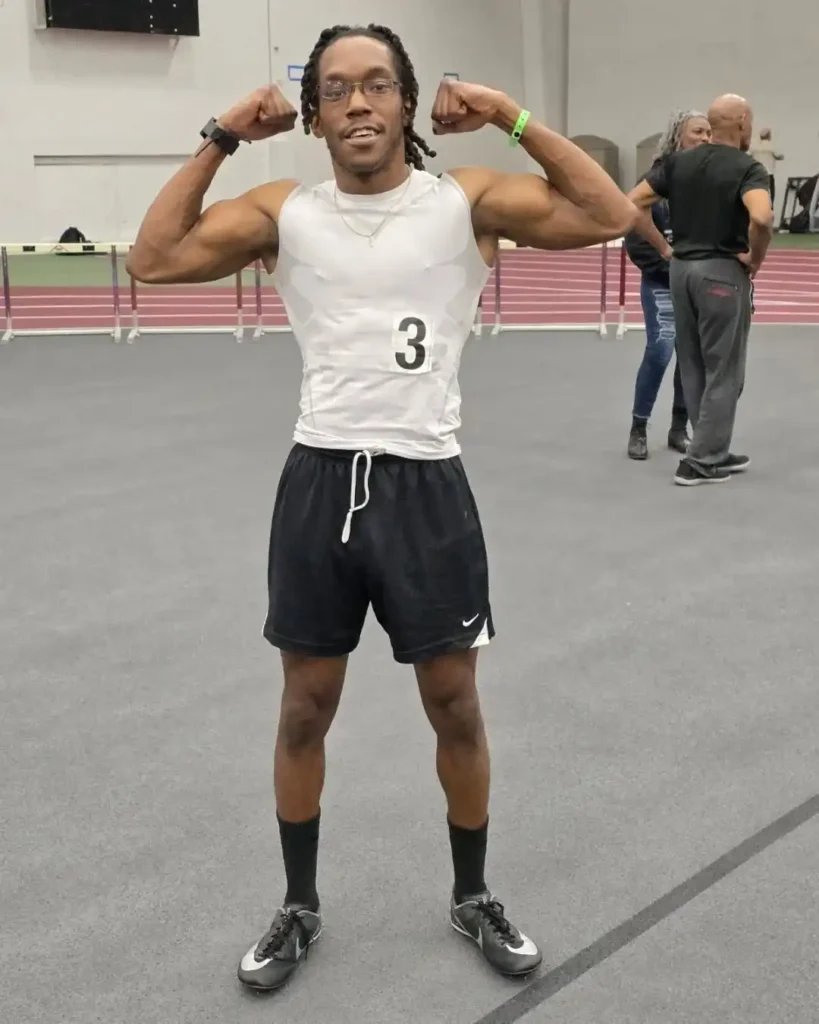 Man doing bicep flex at indoor track